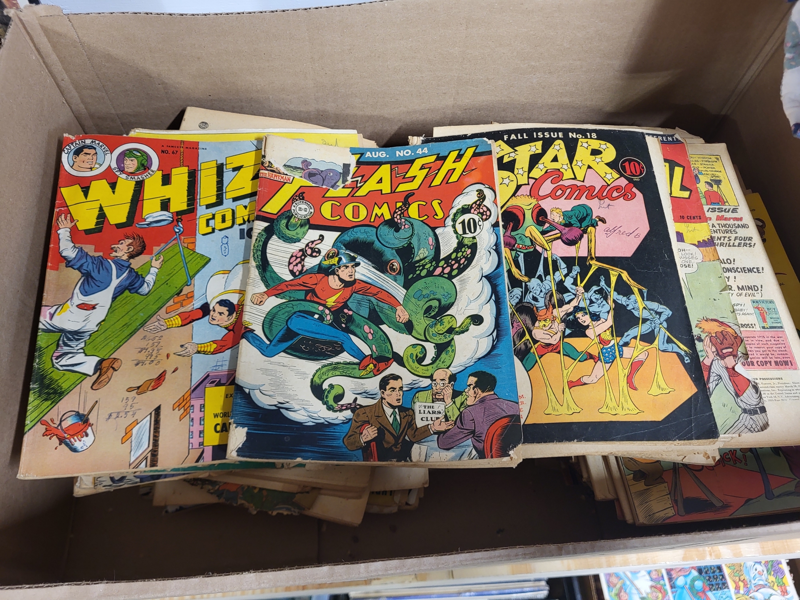 Vintage comic collection featuring Flash Comics, All-Star Comics, and Whiz Comics